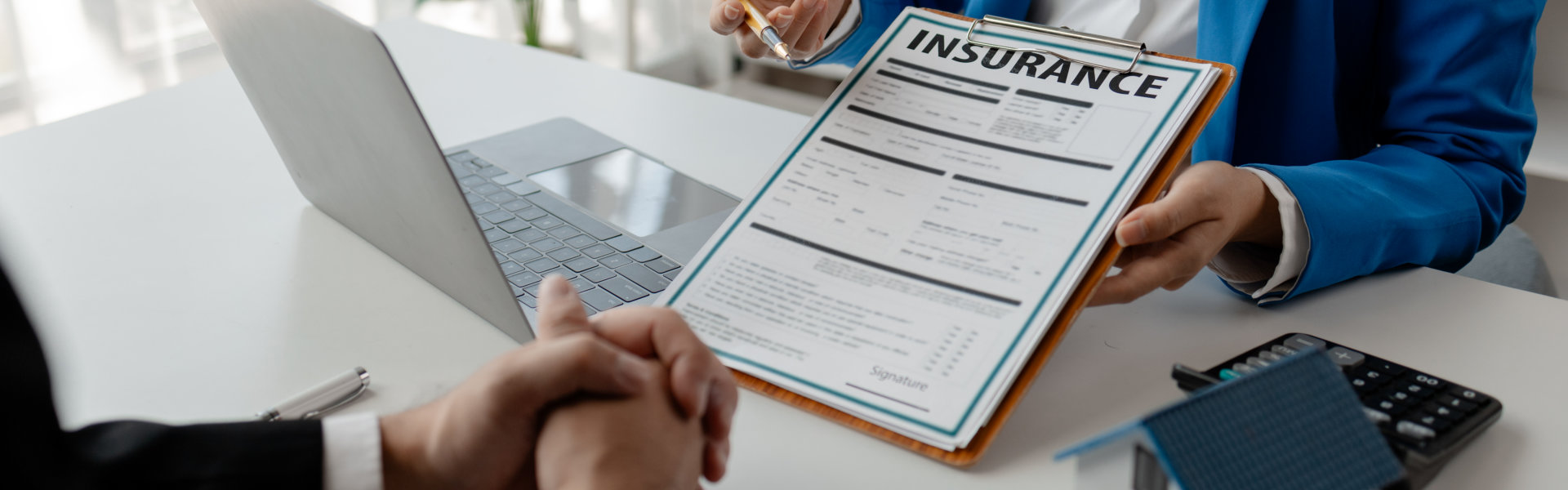 House insurance paperwork, A realtor is explaining home insurance documents to a buyer in his office